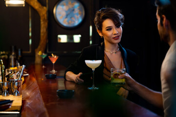 Caucasian man and woman dating and hanging out drinking alcoholic cocktail on holiday event at luxury restaurant bar. Cheerful people enjoy and fun meeting nightlife celebration party at nightclub.