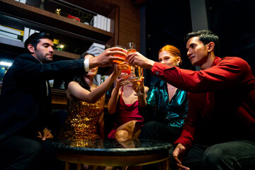Group of Cheerful People toasting champagne glass celebrating holiday event party together at luxury restaurant bar. Happy man and woman friends enjoy and fun hangout meeting nightlife at nightclub.