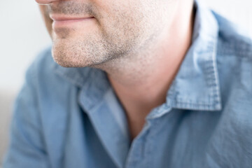 Dojrzały mężczyzna z zarostem delikatnie się uśmiecha.