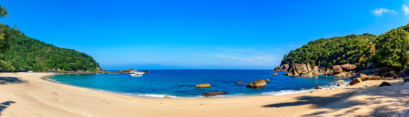Panoramic image of Indaiauba beach on Ilhabela island with hills and forests around it