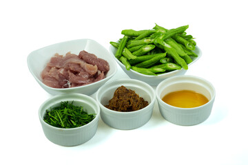 Ingredients for cooking Stir-fried pork and green yard long bean with red curry paste isolated on white background with clipping path top view flat lay. Thai food concept.
