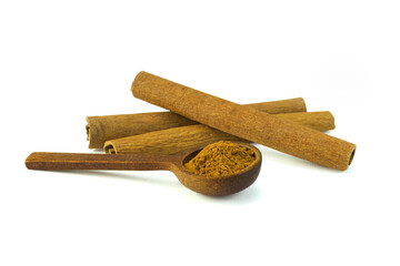 Cinnamon sticks and a wooden spoon of cinnamon powder isolated on white background with clipping path top view flat lay. Used as aromatic condiment and flavouring additive, sweet and savoury dishes.
