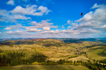 Aerial drone view over autumn forest. Colorful trees in the wood. Autumn forest aerial drone view. Autumn background, aerial drone view of beautiful forest landscape with autumn trees from above.