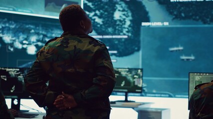 Female technical sergeant monitoring air traffic to detect any enemy aircraft, working in federal...
