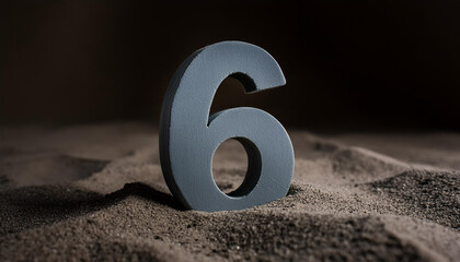 Number 6 made of gray stone isolated with shadow over dark sand.
