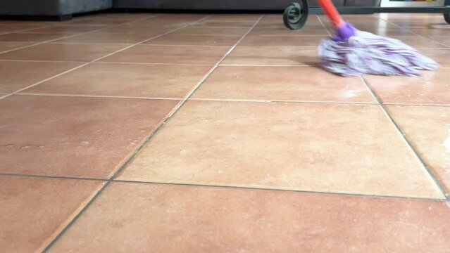 Close-up of a floor on which a mocho is passing to wash the floor.