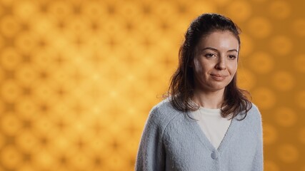Cheerful woman happily doing salutation hand gesture, feeling optimistic. Portrait of joyous caucasian person raising arm to greet someone, gesturing, isolated over studio background, camera A