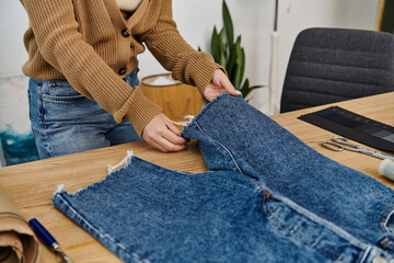 A woman creatively upcycles denim jeans.