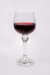 Beautiful glass with red wine on a white background. Transparent glass on a white background