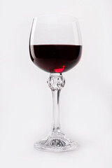 Beautiful glass with red wine on a white background. Transparent glass on a white background