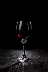 Glass with red wine on a black background.
