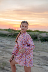 Girl 10-13 years old at sunset on a high mountain.