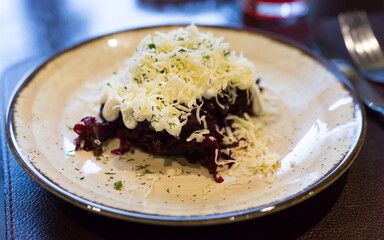 Dish of beets, cheese, mayonnaise on a plate in restaurant