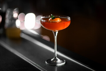 Close-up shot of stemmed glass filled with red-brown cocktail