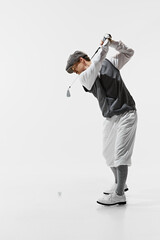Old-School Golf Style. Full-length image of man in classical clothes playing golf isolated on white background. Concept of sport, retro and vintage, active lifestyle, hobby