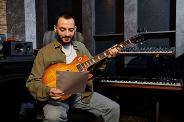 Obraz premium A man playing an electric guitar in a recording studio during a music band rehearsal.