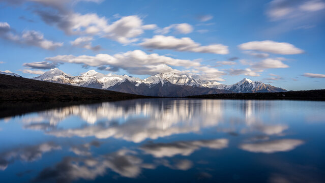 Snow capped mountains, blue sky, and white clouds