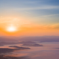 mountain chain silhouette in dense mist at the sunrise