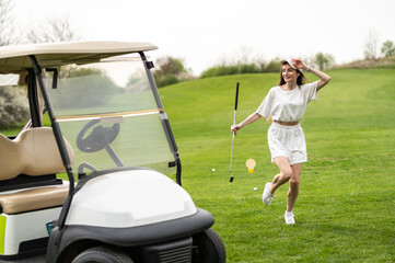 Active woman posing with golf gear by the vehicle outside