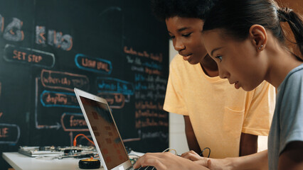 Group of diverse student working together to write program. Multicultural children coding or...