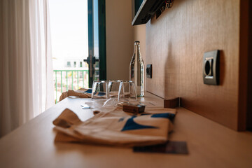 Welcome gifts in the hotel room with three crystal glasses and one crystal bottle filled with water
