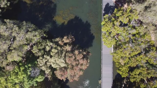 Birds eye view over lake with fountains and footbridge