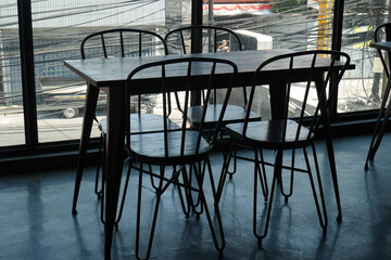 The tables and chairs are set up in a cafe with a classic industrial style that looks empty without visitors.