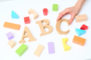 カラフルな積み木と「ABC」と並べられたアルファベットの木製ブロック