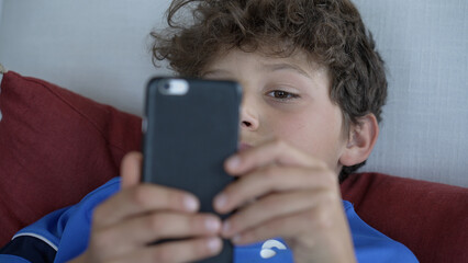 Young Boy Engrossed in Smartphone - Modern Childhood and Digital Interaction