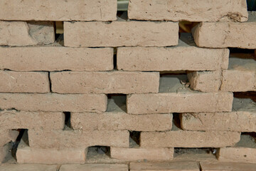 wall of adobe mud bricks leaning against each other one on top of the other