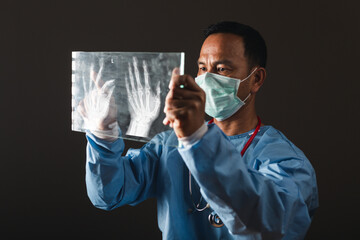 Doctor looking the x-ray picture of hand in patient's room hospital. healthy concept.