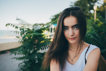 Fototapeta premium A woman with long hair is sitting on a bench in a park