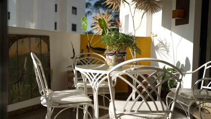 Tranquil Outdoor Patio Setting with White Wrought Iron Furniture and Decorative Plants