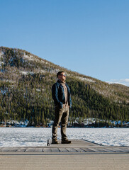 Man Overlooking Frozen Lake in Colorado Mountains