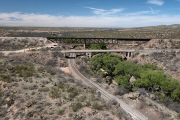 Aerial view of railroad tracks, bridge overpasses in desert landscape