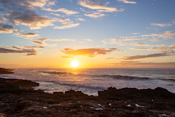 Stunning sunset over the ocean with waves in Hawaii.