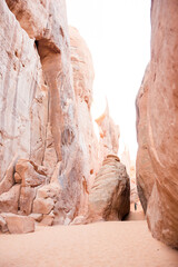 Small asian lady standing in the distance of massive clay rocks