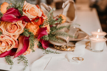 Bouquet with wedding rings, candles, and shoes