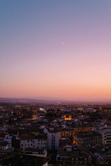 The moon rising over Granada Spain at sunset.