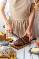 a girl cuts homemade bread on a wooden board