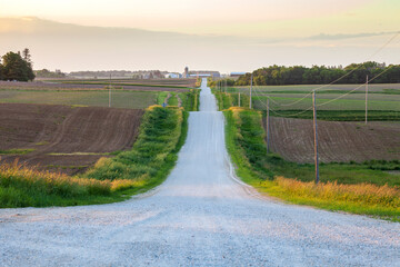 Dirt road in the farmland of northeastern Iowa at dusk on a spring evening