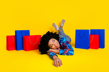 Full size photo of nice young woman lay floor look empty space wear pullover isolated on yellow...