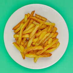 assiette de frites, vue du dessus, isolée sur un fond vert