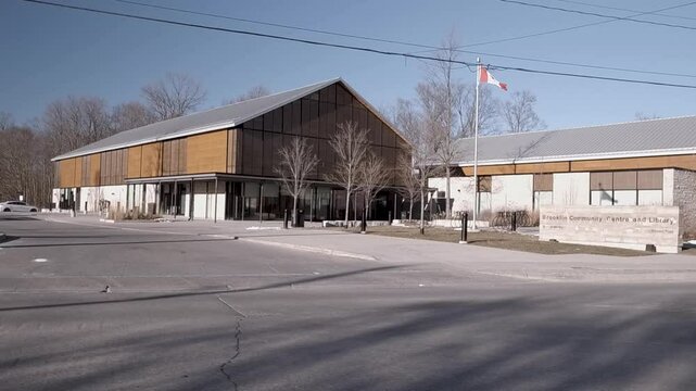 Slow Motion Moving along the sidewalk across the street from the Brooklin Library in Brooklin Ontario Canada