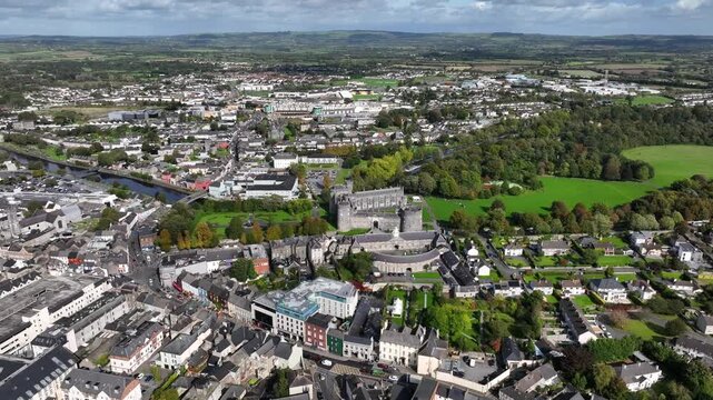 Kilkenny Castle, County Kilkenny, Ireland, September 2023. Drone at a higher angle orbits revealing the elegant gardens and river Nore with the Church of Saint John the Evangelist in the distance.