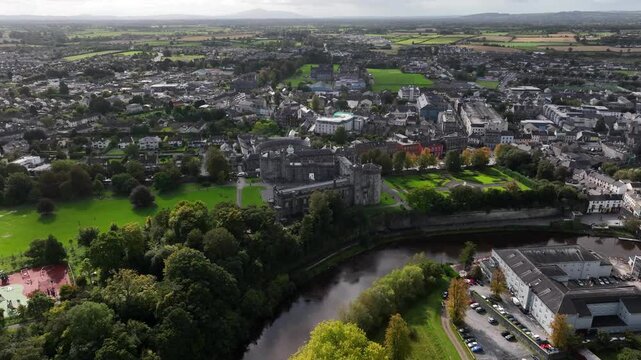Kilkenny Castle, County Kilkenny, Ireland, September 2023. Drone at a higher angle orbits above the River Nore while gradually descending with views south revealing the elegant formal Gardens.