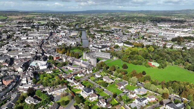 Kilkenny Castle, County Kilkenny, Ireland, September 2023. Drone at a higher angle orbits with Kilkenny Design Workshop in the foreground with the Church of Saint John the Evangelist in the distance.