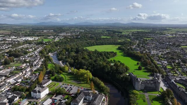 Kilkenny Castle, County Kilkenny, Ireland, September 2023. Drone at a higher angle pushes east along the River Nore with Mount Leinster and the Blackstairs Mountains of County Carlow in the distance.