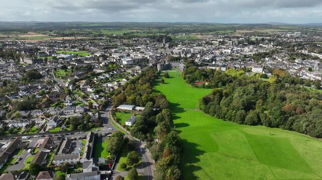 Kilkenny Castle, County Kilkenny, Ireland, September 2023. Drone at a higher angle gradually orbits the grounds with St Canice's Cathedral and Saint Mary's Cathedral in the distance.