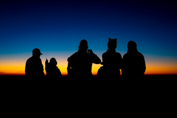 Fototapeta premium Adventure Friendship at Sunset: Silhouetted Group of Friends Embrace Nature's Beauty, Summer Journey of Hiking and Trekking Together in Majestic Mountain Landscapes, Enjoying Outdoor Activities